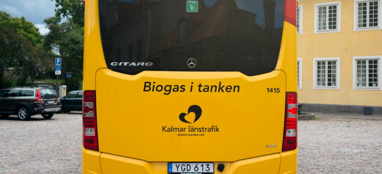 Bild på en buss bakifrån som står på ett torg