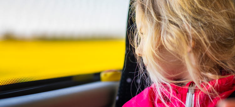 Flicka åker buss och blickar ut över landskapet