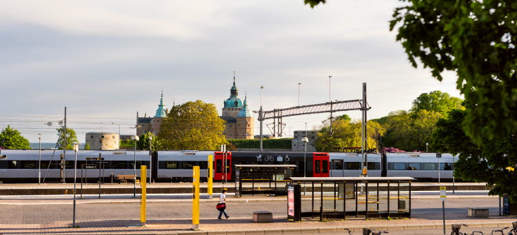 Bild på ett Öresundståg på Kalmar C med Kalmar slott i bakgrunden.