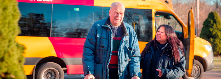 Två personer går ifrån en KLT-buss.