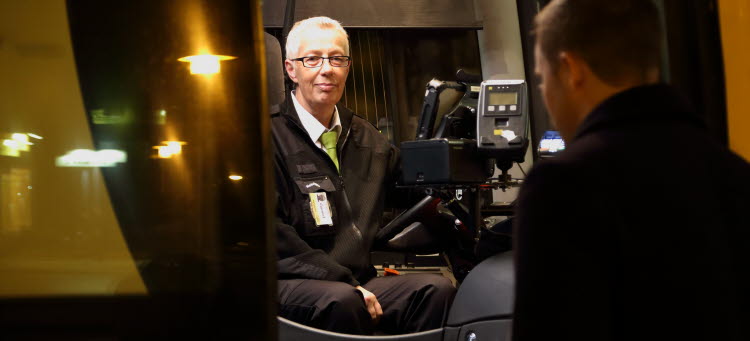 bussförare kvällstid som tar betalt av en resenär