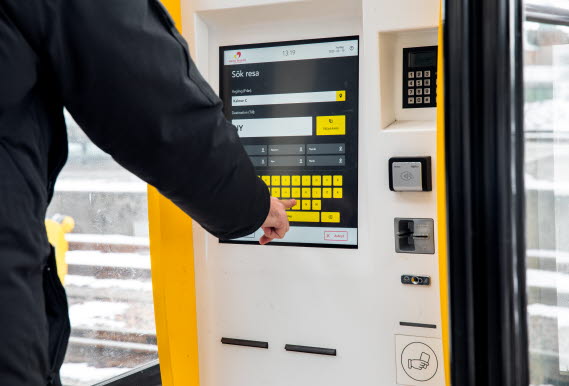 Person köper biljett via en biljettautomat