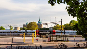 Bild på ett Öresundståg på Kalmar C med Kalmar slott i bakgrunden.